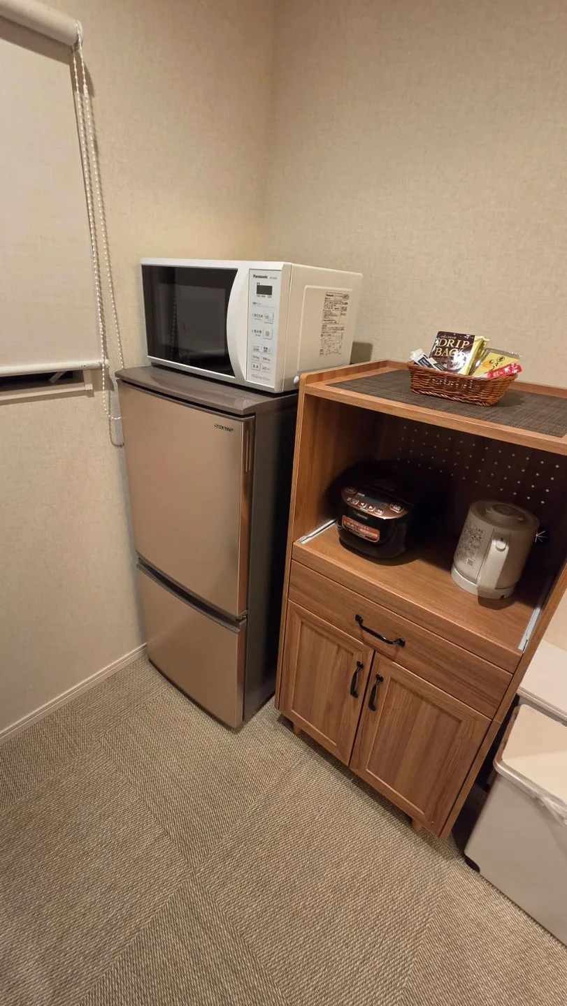 房內的冰箱、微波爐、電鍋與熱水壺