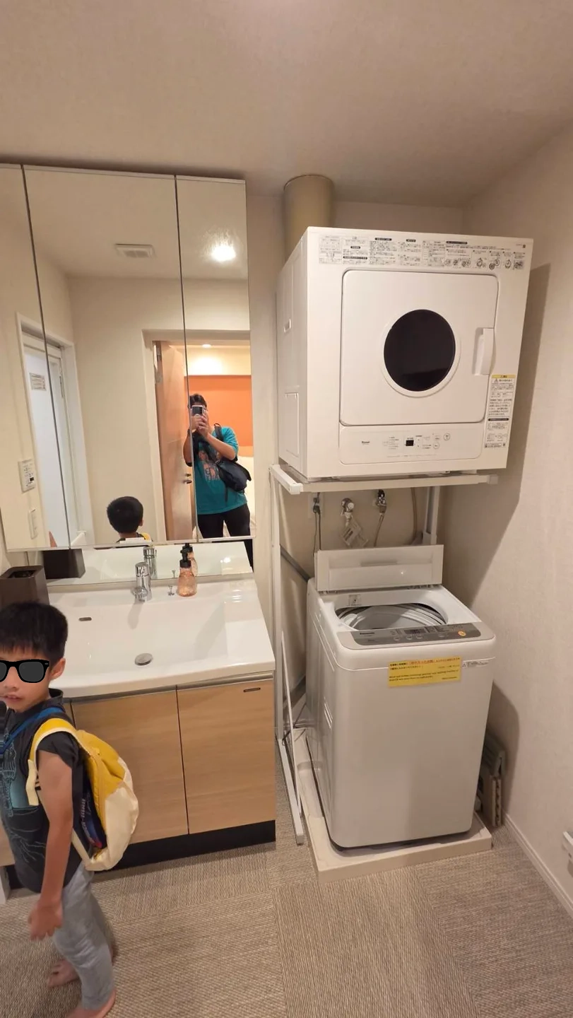 洗手台旁設有洗衣機與烘衣機